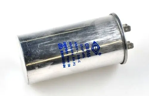 Zylindrischer Metallkondensator von Remko mit zwei anschlussartigen Pins, beschriftet mit elektrischen Spezifikationen, auf einem weißen Hintergrund.