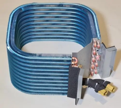Laminierter Wärmetauscher mit blauen Lamellen und vernickelten Anschlüssen, hergestellt von Remko. Die Konstruktion zeigt eine kompakte, robuste Bauweise.