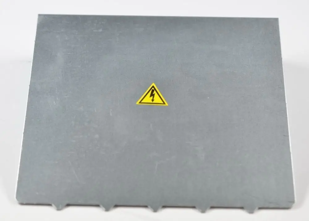 Gehäusedeckel aus Metall mit gelbem Warnsymbol für elektrische Gefahr, hergestellt von Remko. Die Oberfläche ist grau und unbeschriftet.