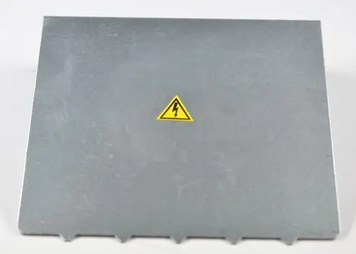 Gehäusedeckel aus Metall mit gelbem Warnsymbol für elektrische Gefahr, hergestellt von Remko. Die Oberfläche ist grau und unbeschriftet.
