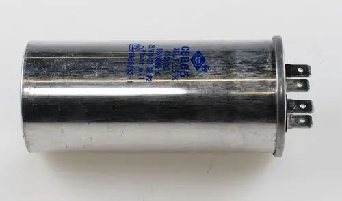 Kondensator mit einer Metalloberfläche und mehreren Anschlussstiften, hergestellt von Remko. Der Kondensator ist typischerweise für den Einsatz in Kompressoren geeignet.