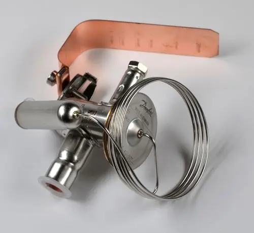 Thermoventil mit Metallkomponenten und Kupferband, hergestellt von Remko. Das Gerät zeigt eine kreisförmige Anzeige sowie verschiedene Anschlüsse und Steuermechanismen.