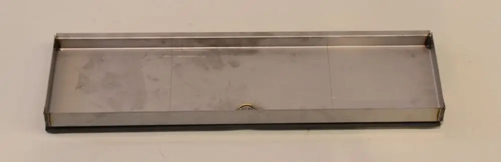 Kondensatfalle aus Metall mit flachem Design und einer zentralen Aussparung. Die Konstruktion ist stabil und eignet sich für den Einsatz in Verbindung mit Geräten von Remko.