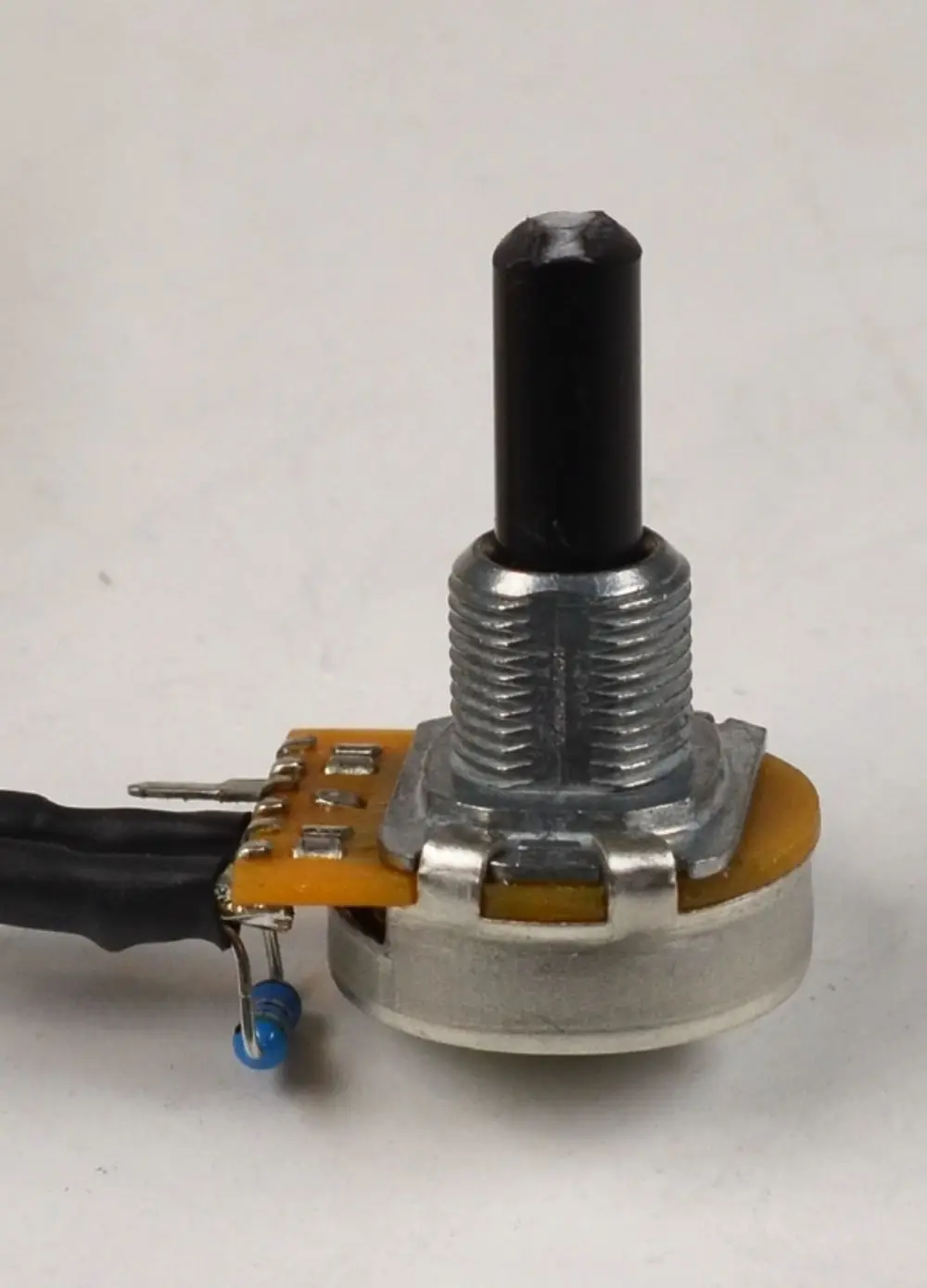 Drehpotentiometer mit schwarzem Drehknopf und Lötanschlüssen, montiert auf einer Platine. Einsatzmöglichkeiten in elektronischen Geräten, hergestellt von Remko.