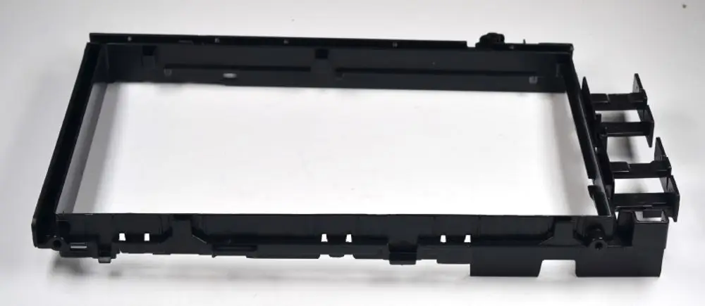 Schwarzes Montageblech, geeignet für die Steuerplatine, mit mehreren Befestigungselementen auf der Seite. Produkt von Remko.