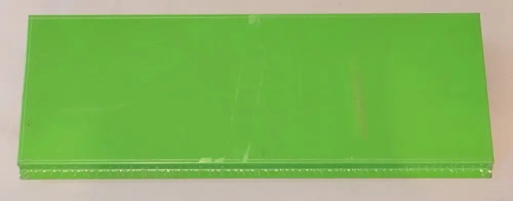 Grüne Abdeckung von Remko, flach und rechteckig, auf einer neutralen Oberfläche platziert.
