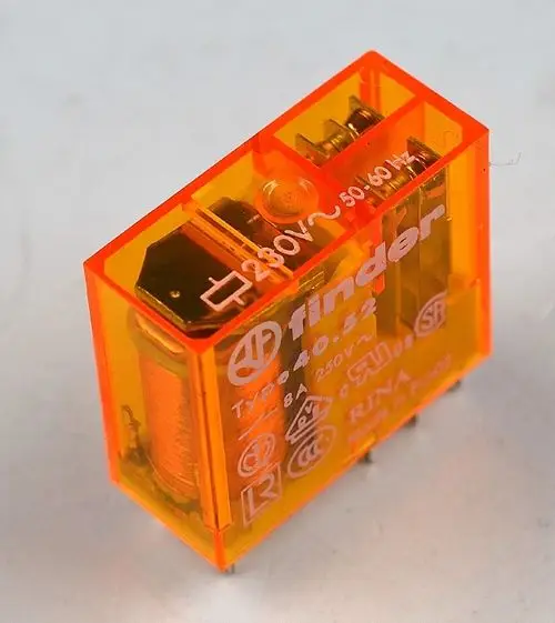 Oranges Relais mit transparentem Gehäuse, das die elektrischen Kontakte zeigt. Vorderseite beschriftet mit technischen Daten. Produkt der Marke Remko.