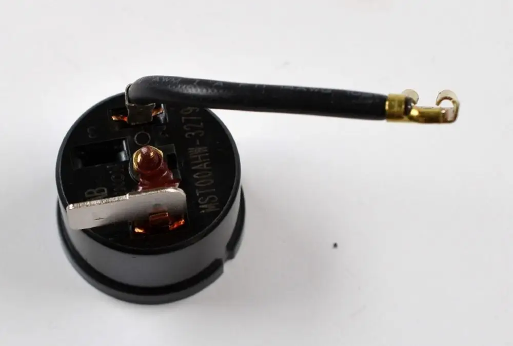 Thermoschalter mit einem runden, schwarzen Gehäuse, vier Anschlussklemmen und einem Kabel, produziert von der Marke Remko.