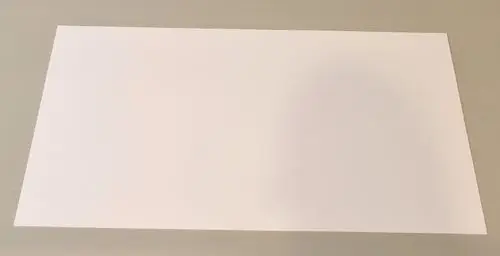 Weißes Kunststoffblatt auf grauem Untergrund, gerade Kanten, flache Oberfläche. Teil eines Luftkanalsystems, möglicherweise von der Marke Remko.