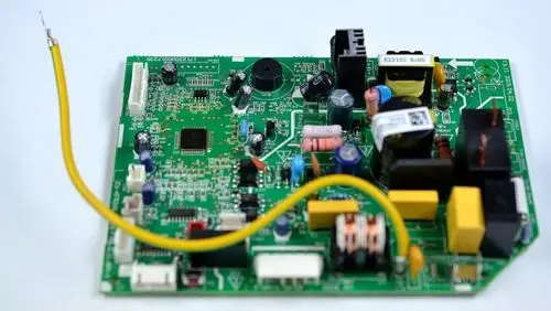 Leiterplatte von Remko, mit verschiedenen elektronischen Bauteilen wie Widerständen, Kondensatoren und einem Kühlkörper auf grünem Trägermaterial. Verbindung mit gelbem Kabel.
