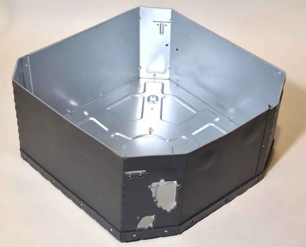 Geräteteil von Remko, quadratisches Gehäuse aus Metall, mit innerer Verstärkung und einem Öffnungselement, auf hellen Hintergrund.