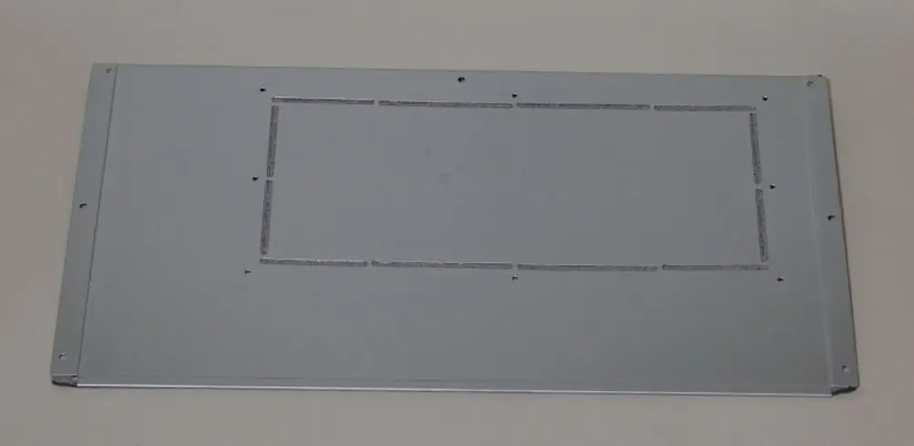 Metallplatte in silberner Farbe, flach und rechteckig, mit geprägten Linien in der Mitte, möglicherweise ein Verkleidungsteil von Remko.