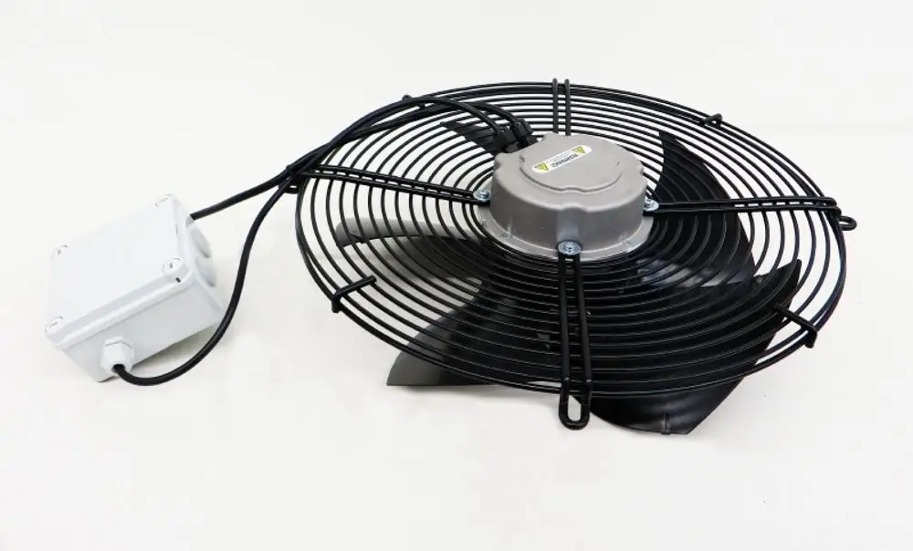 Remko Ventilator mit schwarzem Schutzgitter und Kunststoffgehäuse. Der Motor ist an der zentralen Achse angebracht, Kabelanschluss sichtbar.