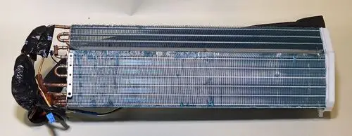 Verdampfer mit kupfernen Rohrleitungen und Lamellen, Teil eines Kühlsystems der Marke Remko, montiert auf einer hellen Oberfläche.
