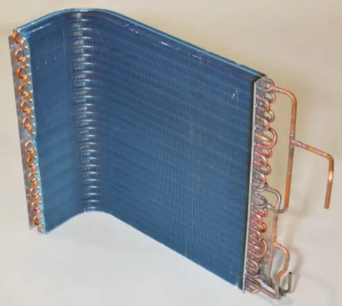 Remko Verflüssiger mit gewellter Oberfläche und Kupferrohren. Das Gerät zeigt eine gebogene Form und ist für die Kälte- oder Klimaanlageninstallation konzipiert.