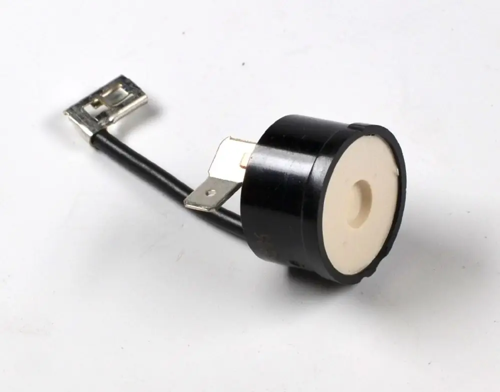 Thermoschalter von Remko mit einem runden Gehäuse und zwei Anschlussklemmen. Der schwarze Körper hat eine weiße Mitte und ist an einem Kabel befestigt.