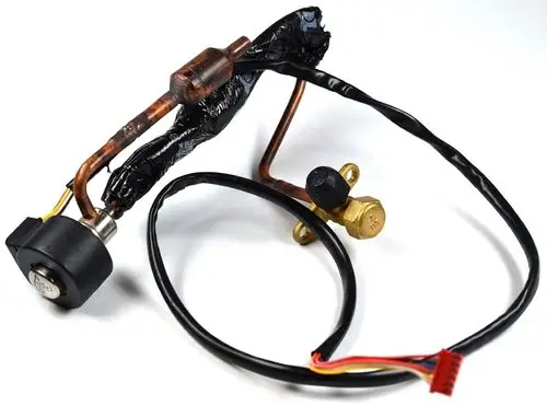 Elektronisches Einspritzventil von Remko mit einer Kombination aus Kupferrohr und elektrischen Anschlussleitungen. Verdeckt angeordnetes Bauteil mit einer schwarzen Ummantelung.