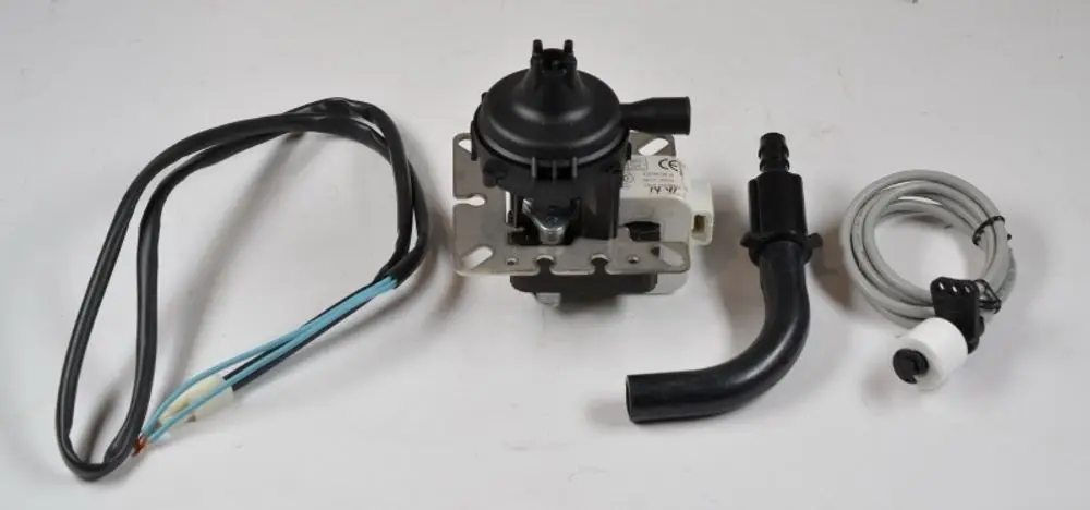 Kondensatpumpe von Remko mit Anschlussleitungen, einer verdeckten Pumpe und einem Gehäuse. Komponenten sind auf einem weißen Hintergrund angeordnet.