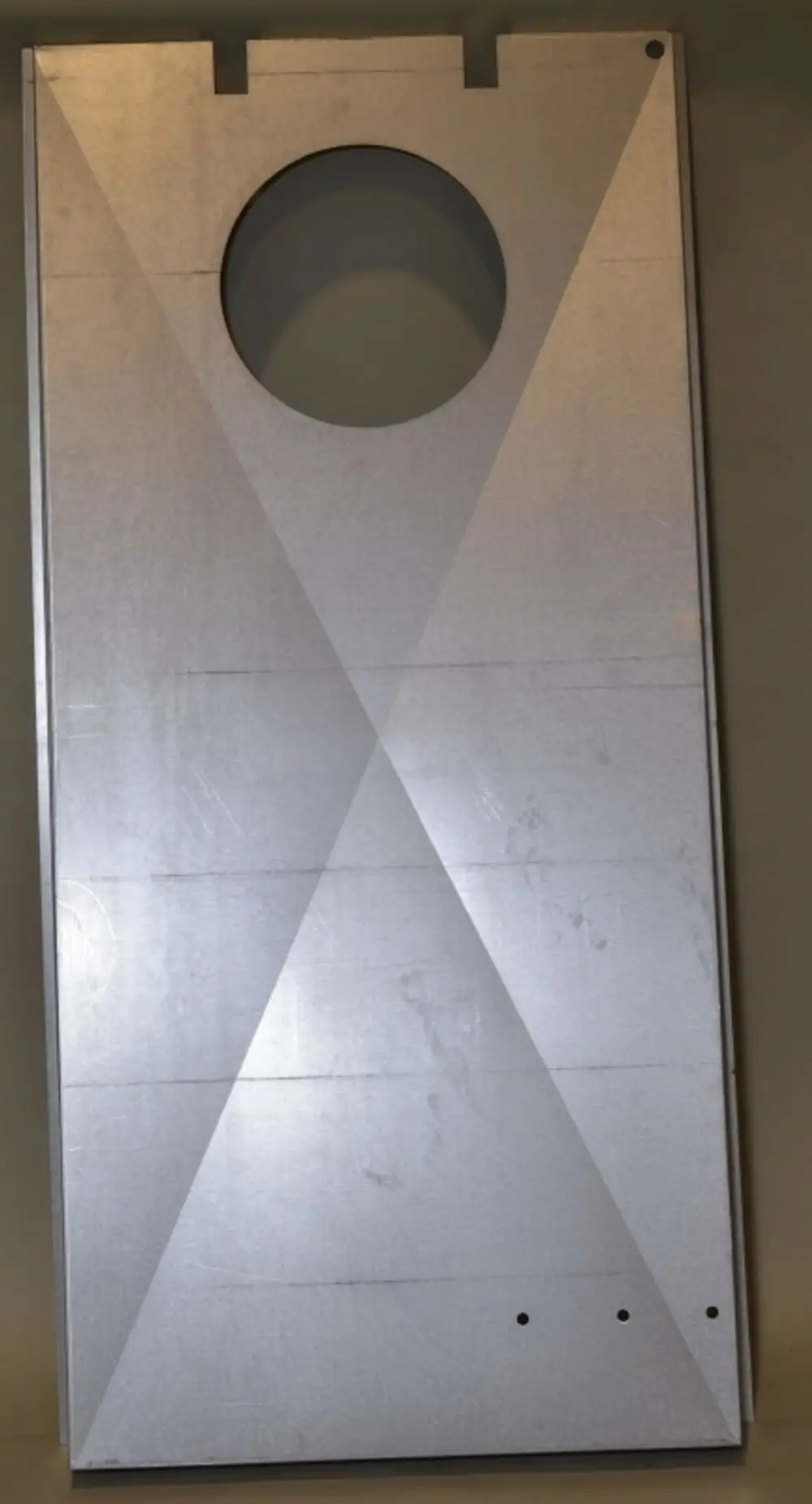 Aluminiumplatte mit kreisförmiger Aussparung, die für die Isolierung eines Remko-Produkts dient. Sichtbare diagonale Muster auf der Oberfläche.