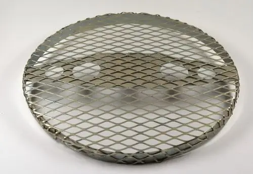 Metallisches Gitter mit runder Form und diamantförmigen Öffnungen, ausgestattet mit zwei Halterungen, vermutlich zur Motorbefestigung. Produkt von Remko.