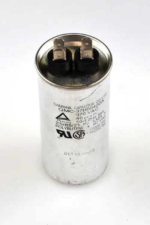 Zylindrischer Kondensator mit zwei Anschlussklemmen, beschriftet mit technischen Daten. Marke Remko ist erkennbar. Silberne Gehäusefarbe, keine speziellen Maße sichtbar.