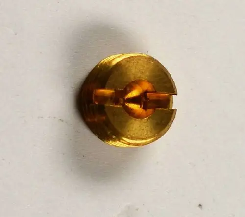 Zündgasdüse von Remko, goldfarbener metallischer Körper mit einem zentralen Kanal und einer runden Öffnung, auf flacher Oberfläche abgebildet.