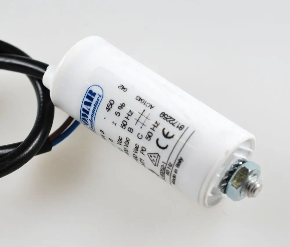 Weißer Kondensator mit Kabeln und Metallbefestigung. Hersteller Remko, spezifiziert für elektrische Anwendungen.