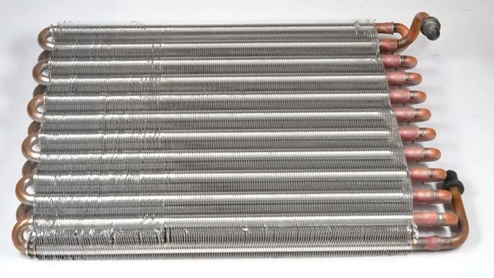Remko-Kondensator mit mehreren kupfernen Rohrleitungen, die durch gewickelte Metallrippen verbunden sind, zur Wärmeübertragung.