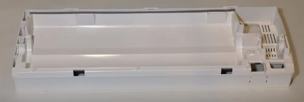 Weiße Kunststoffrückwand von Remko, flache Form mit unterschiedlichen Aussparungen und Lüftungsschlitzen, für technische Anwendungen.