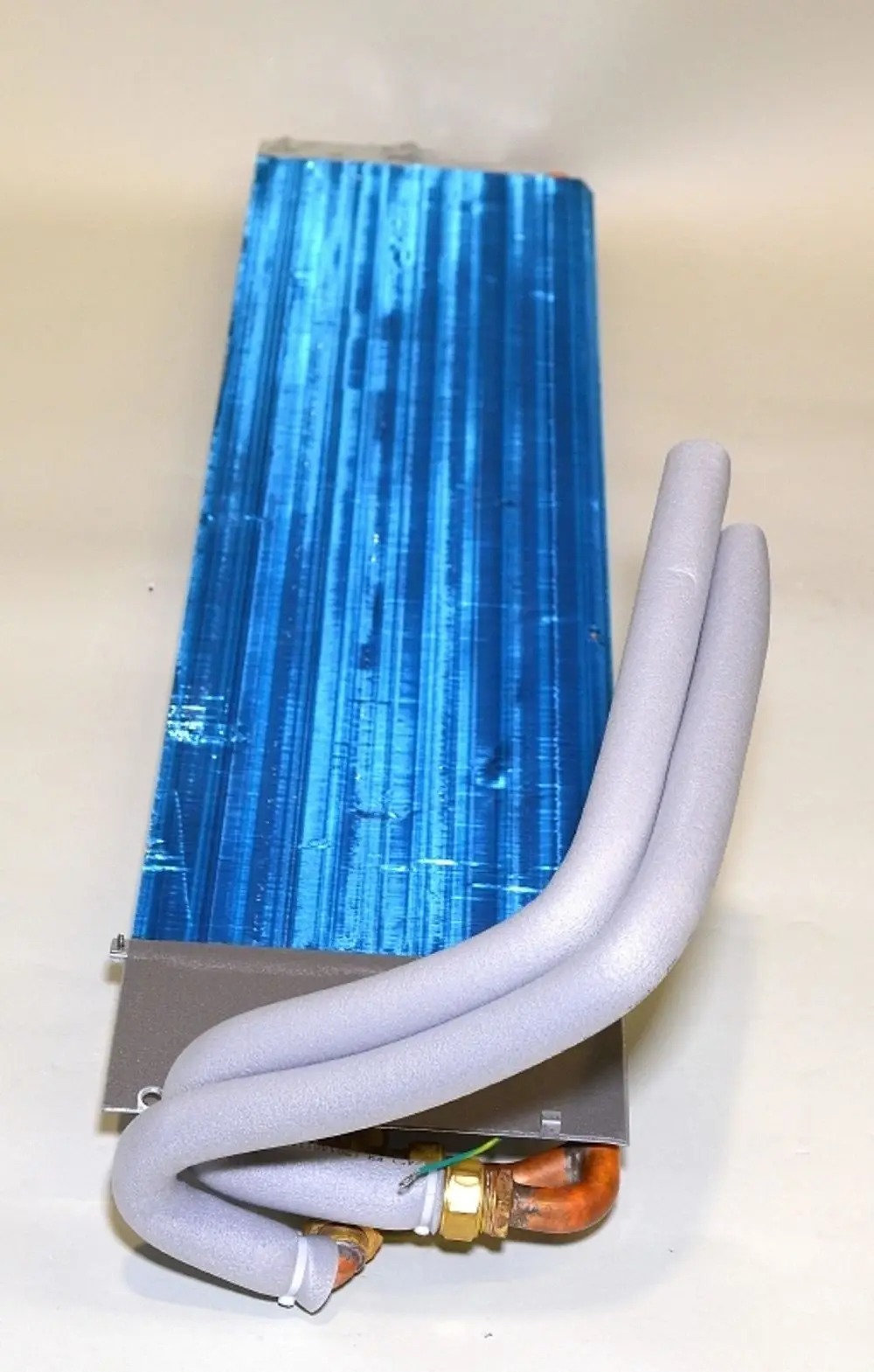Lamellenregister von Remko mit blauer Struktur und flexiblen Anschlussschläuchen. Das Gerät ist für Heizungs- oder Kühlanwendungen konzipiert.