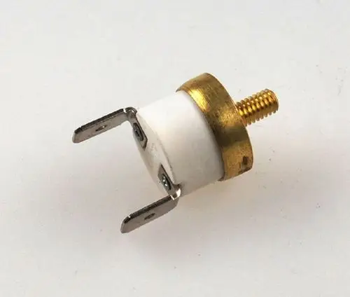 Remko Ventilatorthermostat mit einem runden weißen Gehäuse, goldfarbenem Metallrand und zwei Anschlussplättchen. Schraubengewinde an der Oberseite zur Befestigung.