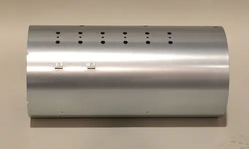 Metallzylinder mit mehreren kleinen Löchern, vermutlich Teil eines Heizsystems von Remko. Die Oberfläche ist glatt und silbern.