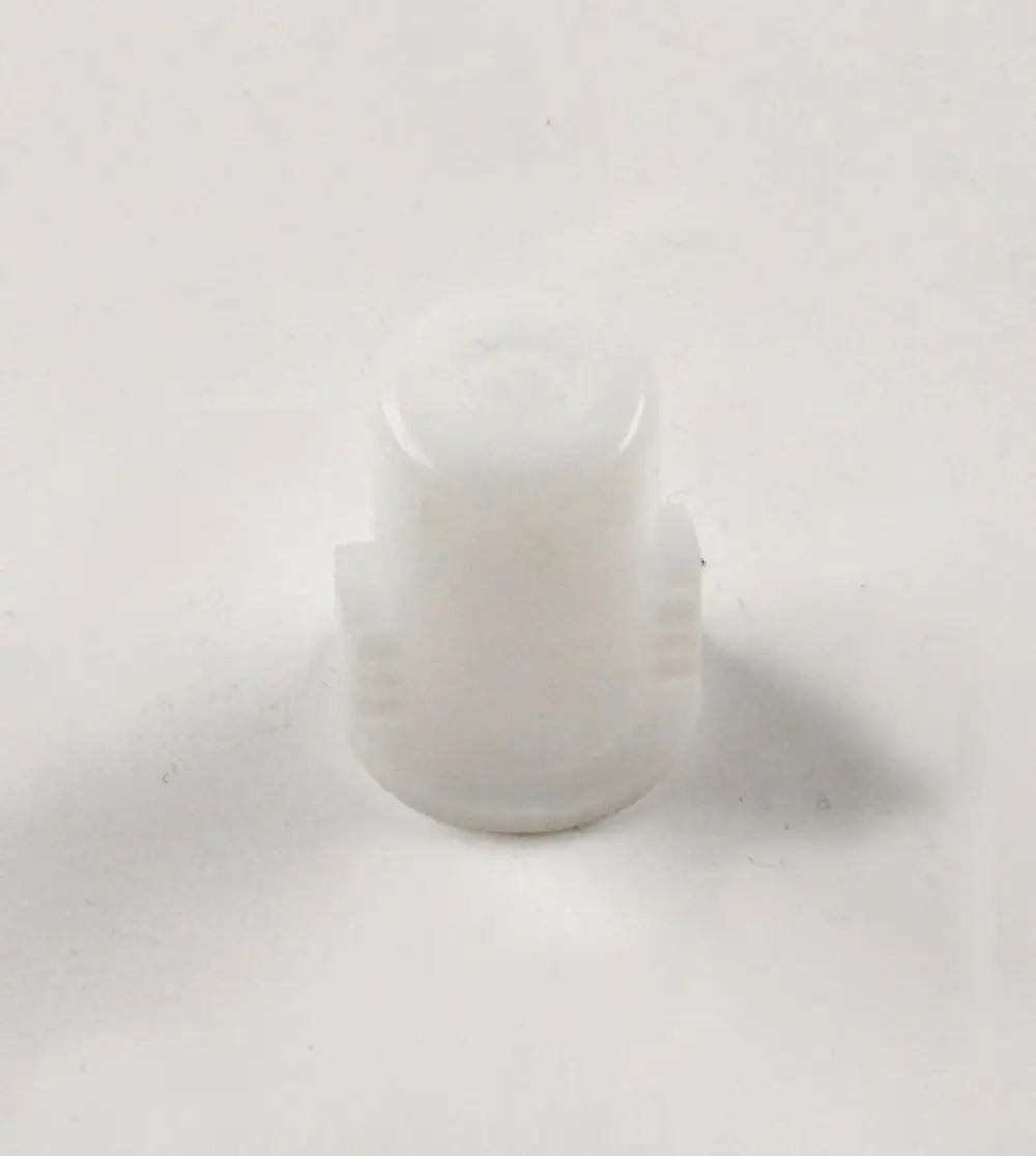 Weißer Kunststoffadapter, möglicherweise für Pumpen, mit zwei seitlichen Rillen. Teil einer Remko-Anlage zur Verbindung oder Montage.