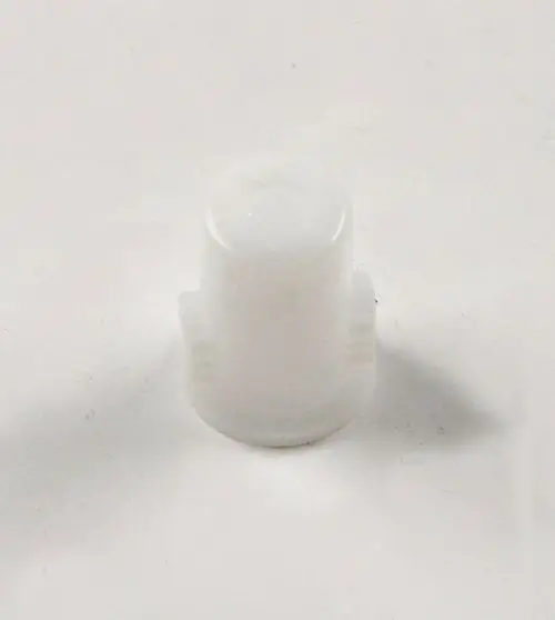 Weißer Kunststoffadapter, möglicherweise für Pumpen, mit zwei seitlichen Rillen. Teil einer Remko-Anlage zur Verbindung oder Montage.