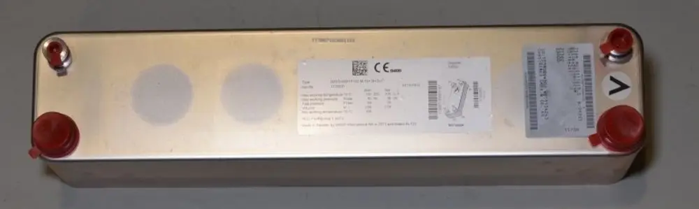 Wärmetauscher von Remko, rechteckige Metallkonstruktion mit zwei rotem Anschlusssockel, diverse technische Daten auf einem Aufkleber, auf einer neutralen Fläche platziert.