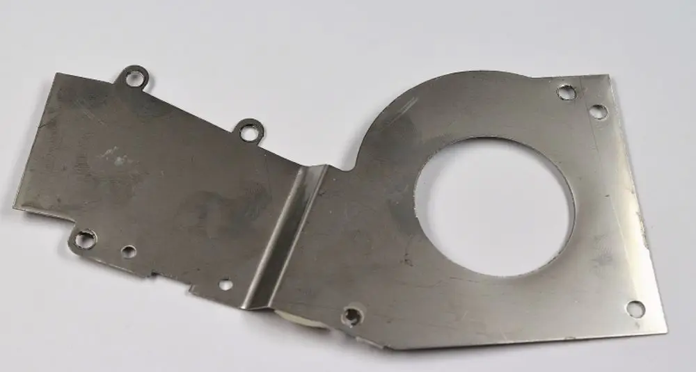 Metallisches Ventilatorgehäuse mit runder Öffnung und mehreren Bohrungen. Produkt von Remko, geeignet zur Montage in Lüftungssystemen.