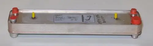 Verdampfer von Remko mit länglichem, flachem Gehäuse aus Metall. An den Enden sind zwei rote und zwei gelbe Anschlüsse zu sehen. Auf der Oberfläche sind technische Informationen sichtbar.
