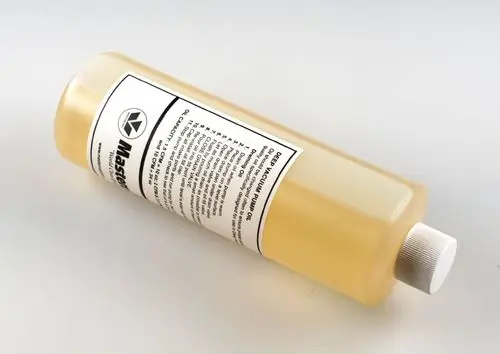 Flasche mit transparentem Inhalt, auf weißem Etikett sind Anweisungen und Hinweise zur Verwendung eines Ersatzöls für Vakuumpumpen der Marke Remko abgedruckt.