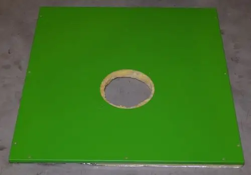 Isoliertes Verkleidungsblech in Grün mit runder Öffnung in der Mitte. Der Untergrund ist grau. Möglicherweise von der Marke Remko.