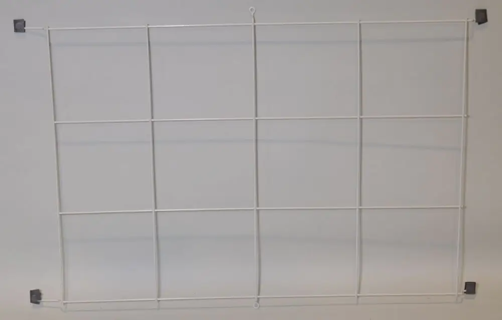 Weißes Gitter mit rechteckiger Struktur, möglicherweise zur Wandmontage geeignet. Sichtbare Befestigungselemente in den Ecken. Produkt von Remko.