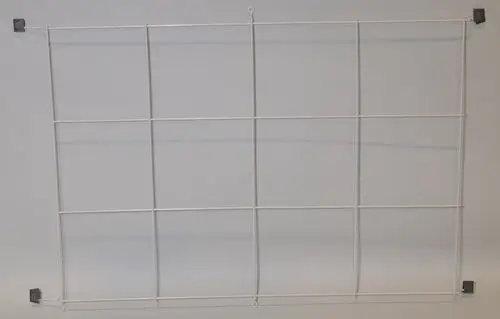 Weißes Gitter mit rechteckiger Struktur, möglicherweise zur Wandmontage geeignet. Sichtbare Befestigungselemente in den Ecken. Produkt von Remko.