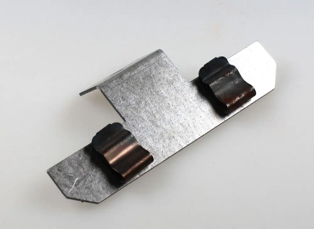 Halterung aus Metall mit zwei gebogenen Auflageflächen. Eignet sich zur Befestigung von Sensoren oder ähnlichen Komponenten, möglicherweise für Remko Produkte.
