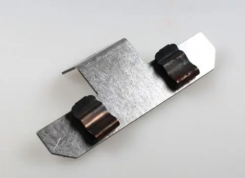 Halterung aus Metall mit zwei gebogenen Auflageflächen. Eignet sich zur Befestigung von Sensoren oder ähnlichen Komponenten, möglicherweise für Remko Produkte.