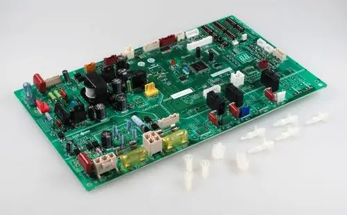 Steuerplatine von Remko, grüne Leiterplatte mit verschiedenen elektronischen Bauteilen, Anschlüssen und mehreren Verbindungselementen. Im Vordergrund sind einige Kunststoffteile sichtbar.