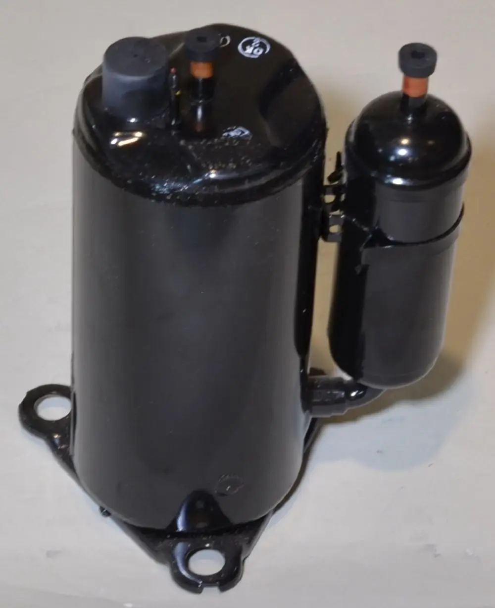 Kompressor von Remko, schwarz lackiertes Metallgehäuse mit zwei Anschlüssen oben. Befestigungsmöglichkeiten an der Unterseite.