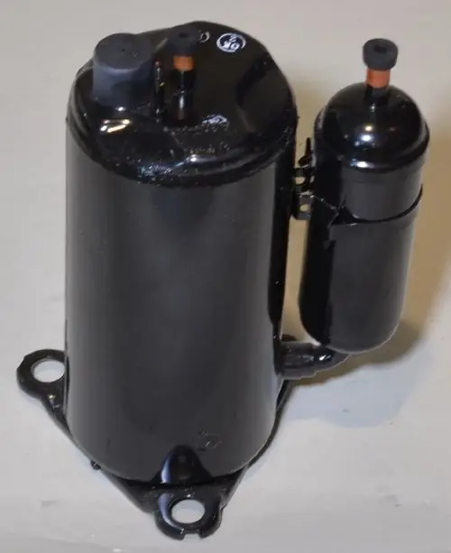 Kompressor von Remko, schwarz lackiertes Metallgehäuse mit zwei Anschlüssen oben. Befestigungsmöglichkeiten an der Unterseite.