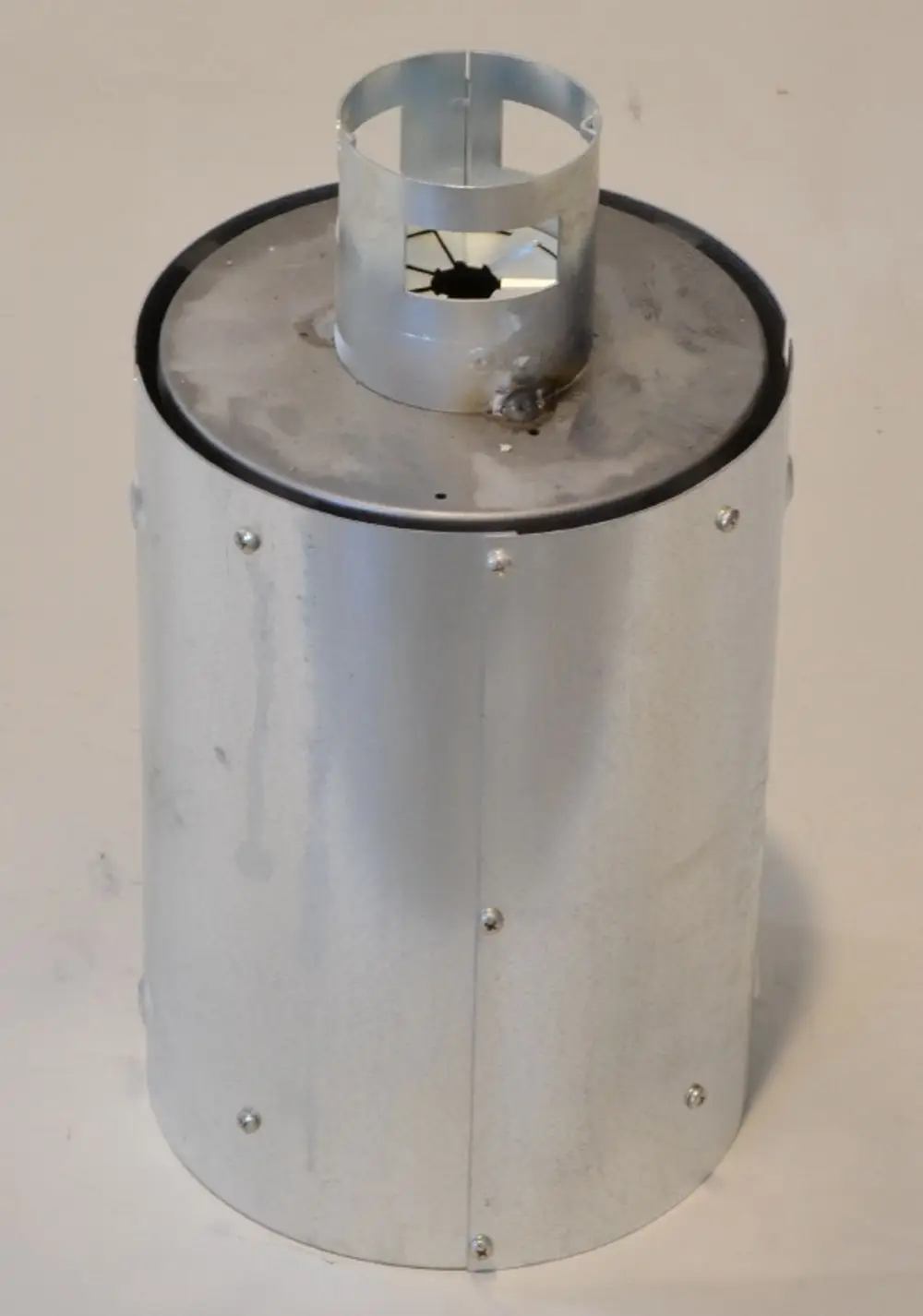 Metallische Brennkammer mit Oberteil und herausragendem Wärmetauscher, hergestellt von Remko. Die Oberfläche ist silbern und zeigt Verarbeitungsdetails wie Schrauben.