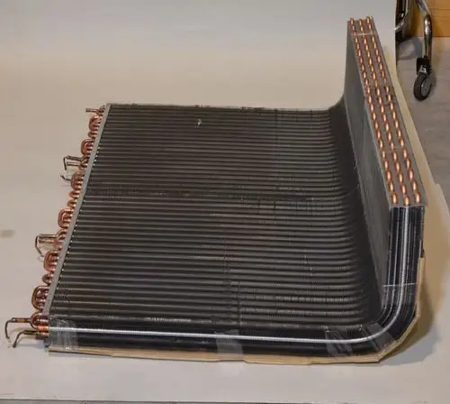 Lamellenverflüssiger mit kupfernen Anschlüssen, schwarz beschichtet, auf einer flachen Unterlage. Ein Produkt von Remko zur Wärmeübertragung in Kälteanlagen.