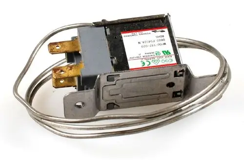 Abtauthermostat mit Fühler von Remko, ausgestattet mit zwei Anschlussklemmen und einer Metallhalterung, umgeben von einem Kabel.