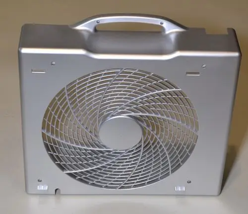 Silberne Rückwand mit spiralförmigem Lüfterdesign, ausgestattet mit einem Griff. Produkt von Remko.